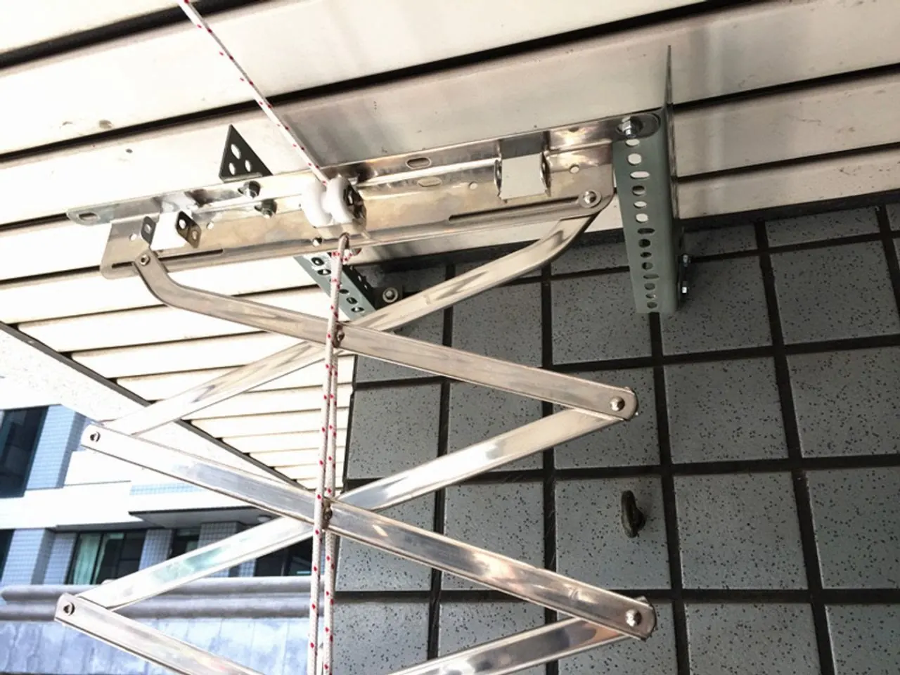 台中不鏽鋼升降曬衣架－磚牆陽台的剪刀式升降架近距離安裝細節